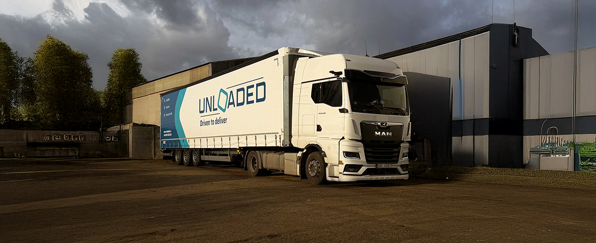 Kamion před budovou s logem UNLOADED.