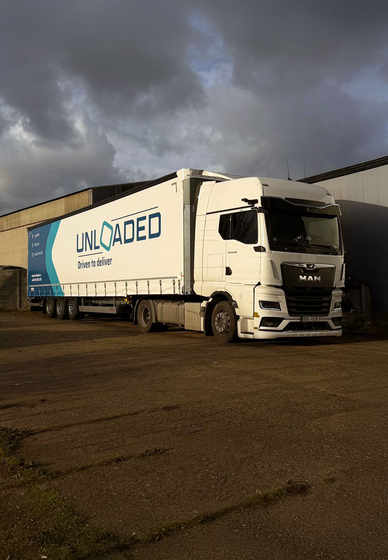Kamion s logem "UNLOADED" na parkovišti.