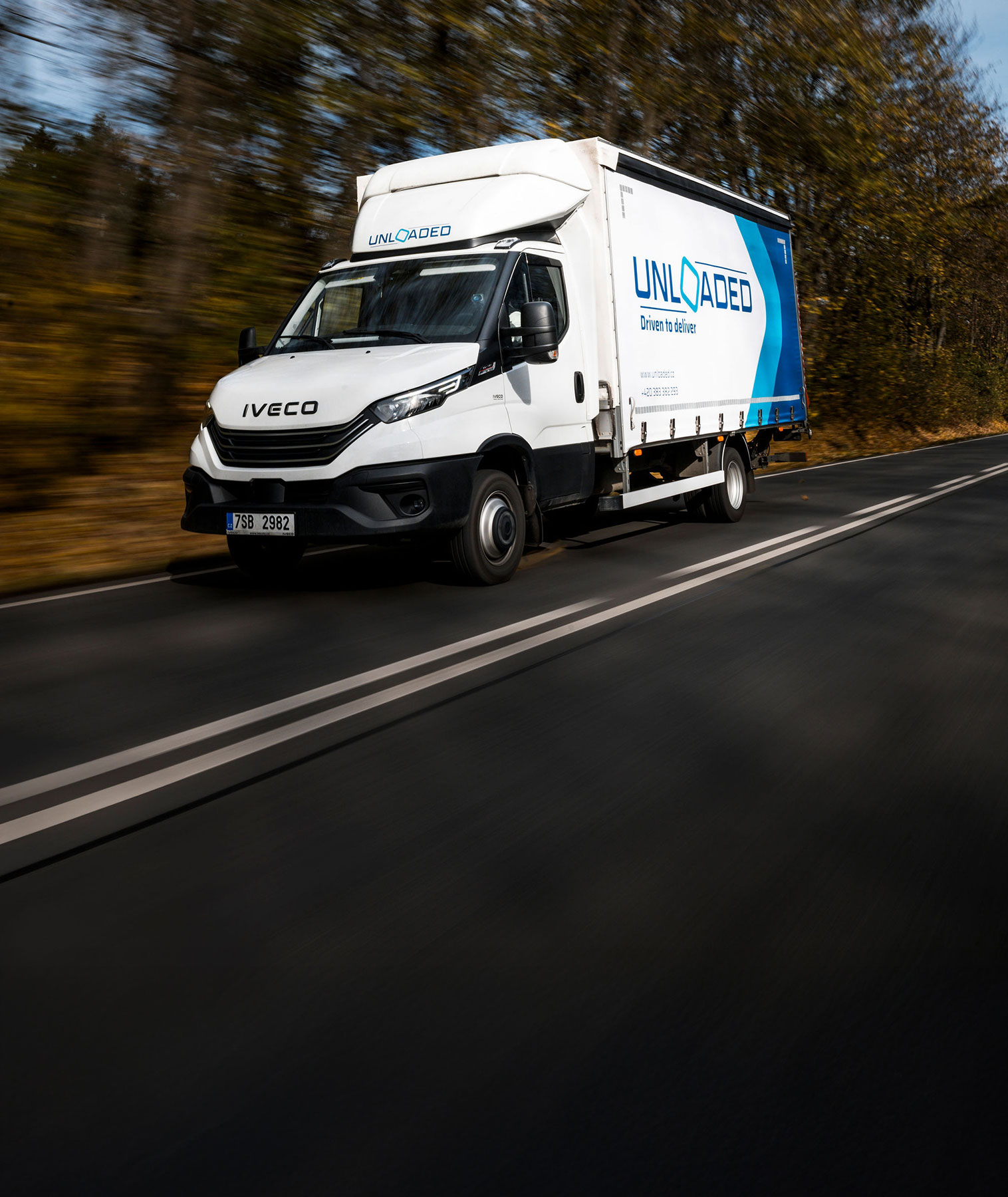 Iveco dodávka na silnici, rychlá jízda lesem.